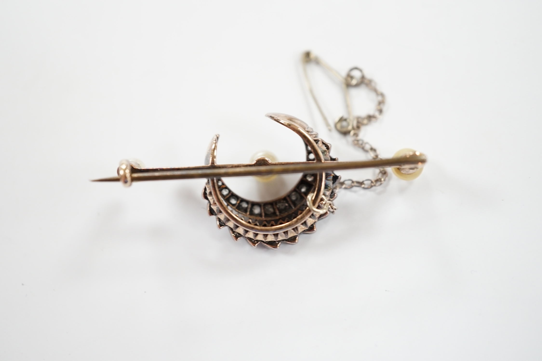 A Victorian yellow and white metal, diamond and pearl set crescent bar brooch, 44mm, gross weight 6.1 grams.